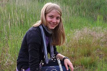 Jugendliche Frau in einer Wiese bei einem ökologischen Jahr