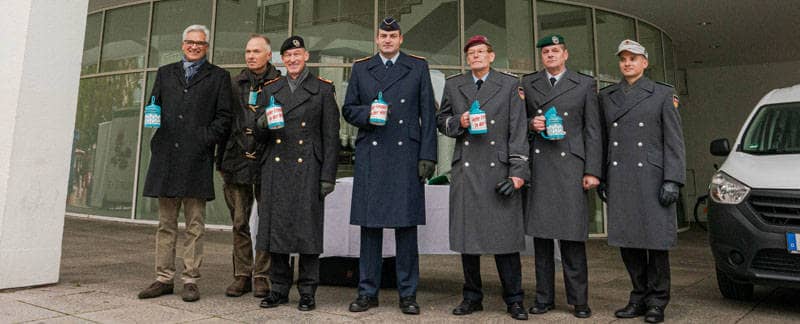 Bundeswehrangehörige und Oberbürgermeister Czisch stehen zum Auftakt der Kriegsgräbersammlung mit Spendendosen bereit.