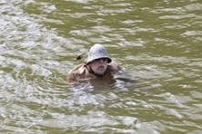Ein älterer Herr mit mittelalterlichem Gewand schwimmt im Wasser.