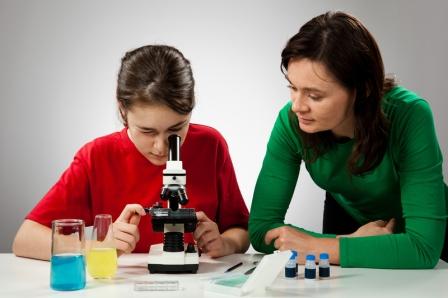 Kind schaut durchs Mikroskop