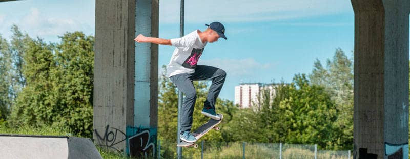 Ein Skateboarder springt mit seinem Board auf einer Skateanlage.