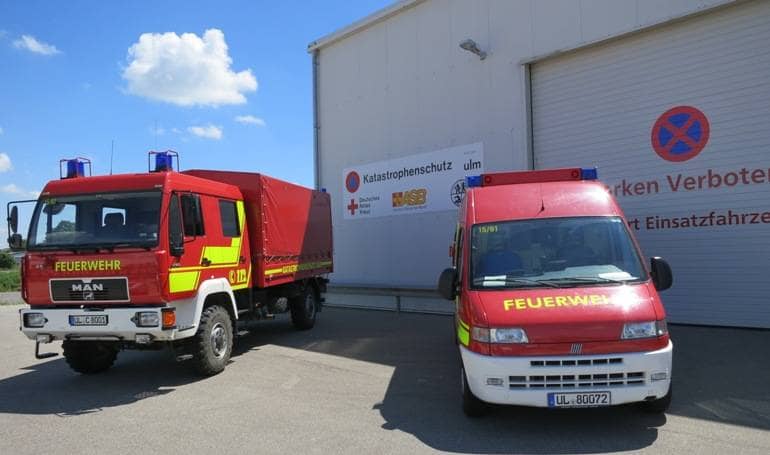 Bild der Katastrophenschutzunterkunft im Industriegebiet Donautal. zwei Katatrophenschutzfahrzeuge sten vor dem Gebäude.