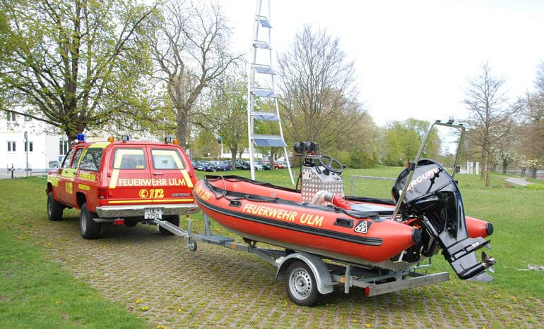 Allradgetriebener Chevrolet Vorrausrüstwagen der Ulmer Feuerwehr zur Spezialrettung als Zugfahrzeug für den Anhänger mit dem Schnellrettungsboot beim Einbooten an der Slipanlage der Donau.