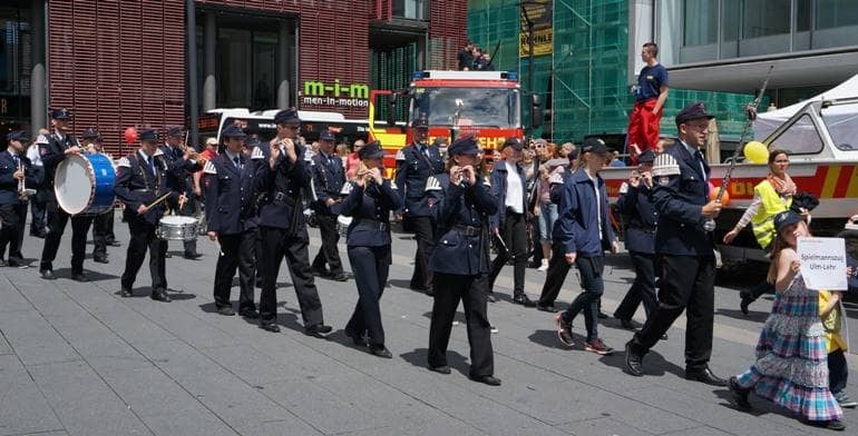 Der Spielmannzug der Feuerwehr Ulm im Festumzug der Parade der Kulturen am Internationalen Tag in der Neuen Mitte in Aktion.