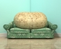 Eine Kartoffel liegt auf einem Sofa.