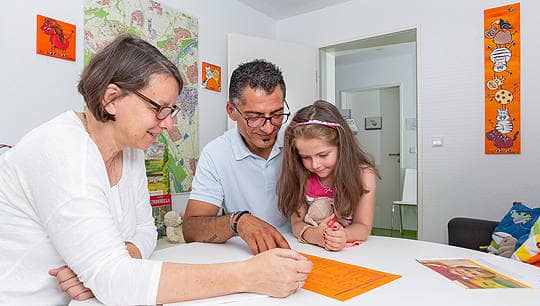 Vater und Tochter im Beratungsgespräch mit einer Mitarbeiterin des Familienbüros der Stadt Ulm