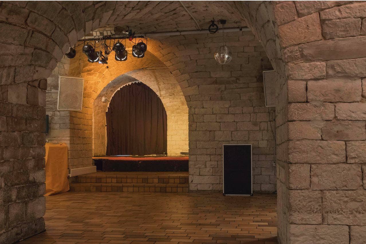 Das Gewölbe innen in der Begegnungsstätte Charivari mit Bühne, Lautsprecherboxen und Lichtstrahlern