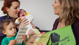 Beraterin mit Babytasche bei junger Familie