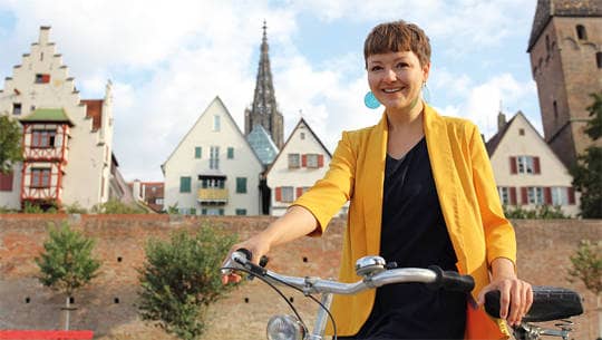 Frau mit Fahrrad vor der Ulmer Stadtmauer