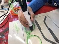 Ein Kind fertigt die Umrisse einer 3D-Brille an.