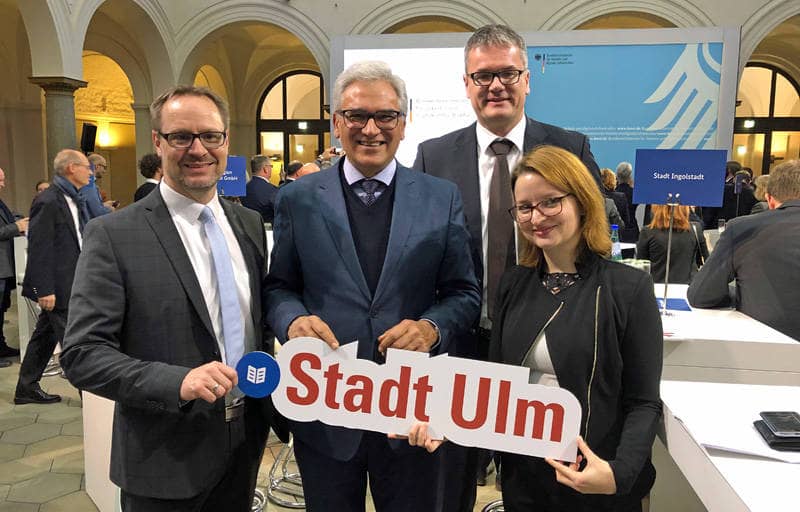Thorsten Freudenberger, Gunter Czisch, Professor Michael Schlick und Ronja Kemmer halten ein Siegerschild mit der Aufschrift "Stadt Ulm" in den Händen.