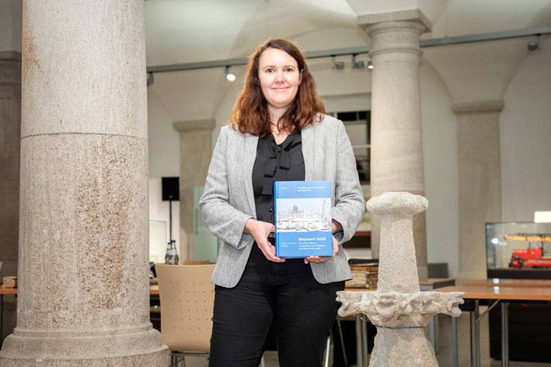 Dr. Anne-Christine Brehm im Gewölbesaal vom Haus der Stadtgeschichte mit ihrem Buch in der Hand