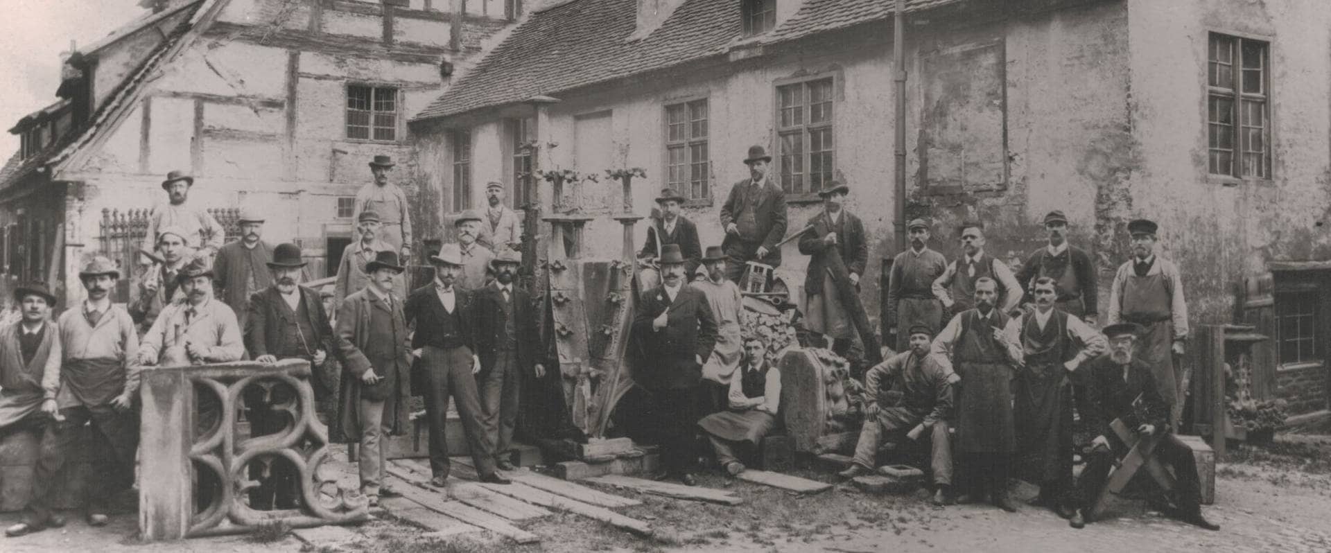 Ein Schwarz-Weiß Bild aus dem Jahr 1899. Die damalige Belegschaft der Münsterbauhütte ist zu sehen.