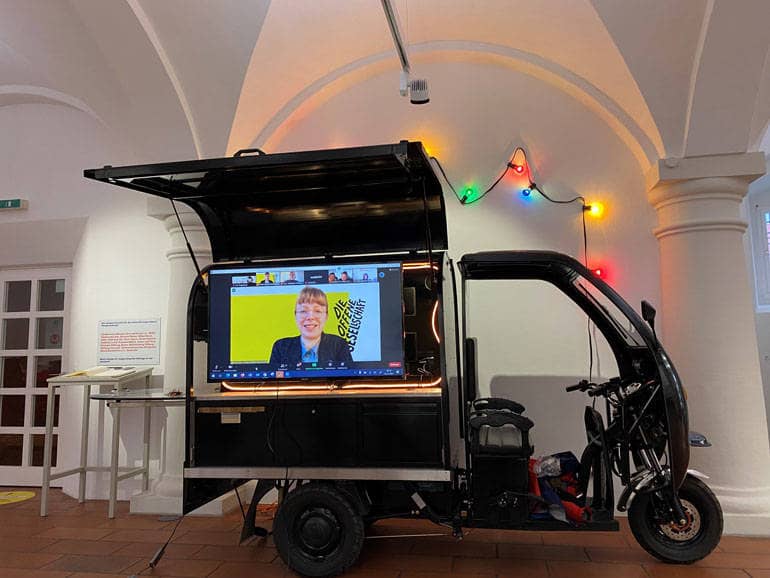 Ein Fahrzeug mit einem integrierten Monitor steht in einem Ausstellungsraum