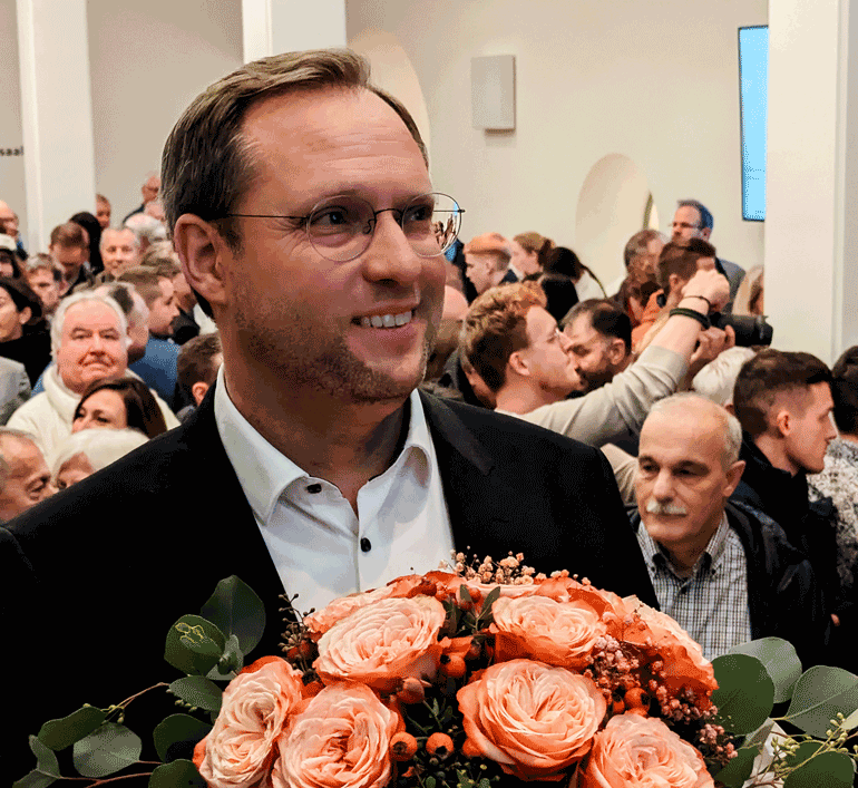 Ein lächelnder Martin Ansbacher mit einem Blumenstraß in der Hand