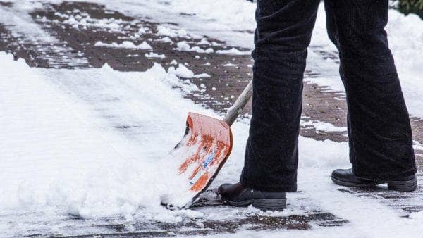Ein Mann räumt Schnee mit einer Schaufel