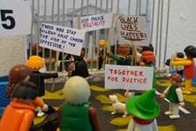 Playmobilfiguren demonstrieren mit Schildern für die Gleichberechtigung aller Menschen.