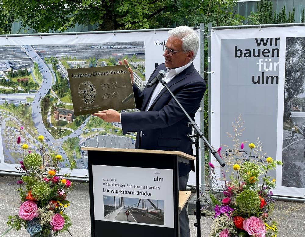 Oberbürgermeister Czisch präsentiert eine Tafel mit dem Abbild von Ludwig Erhard.