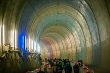 Viele Menschen spazieren durch eine meterhohe Tunnelröhre.