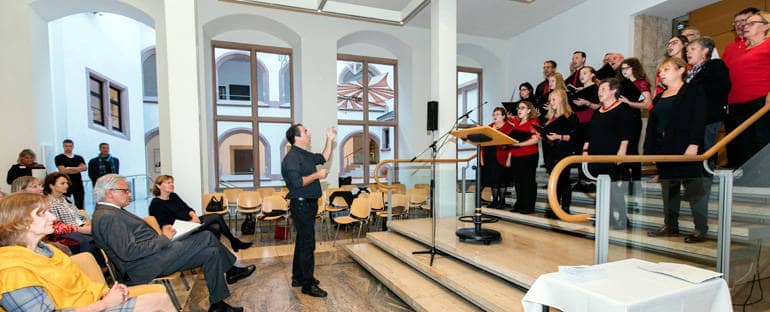 Ein Chor singt vor Publikum im Foyer des Rathauses.