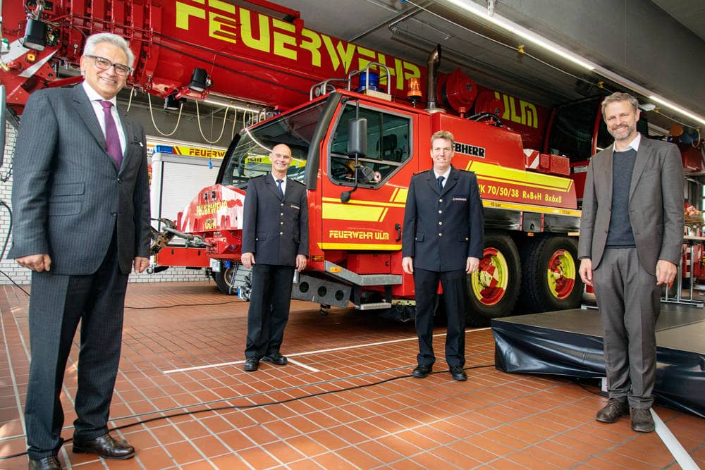  Gunter Czisch, Hansjörg Prinzing, Adrian Röhrle und Bürgermeister Tim von Winning vor einem Feuerwehr-Löschwagen.