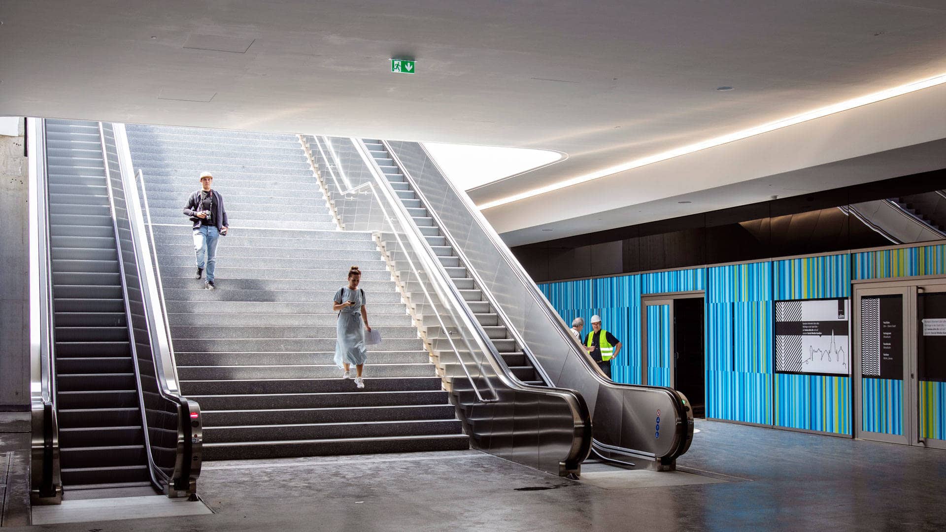 Ein Blick auf die Treppe der neuen Bahnhofspassage. Eine Frau und ein Mann laufen die Treppe gerade herunter.