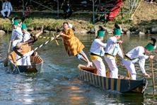  Zwei Stecher, die auf jeweils einem Boot gegeneinander antreten, versuchen, den anderen mit einem gepolsterten Speer ins Wasser zu stoßen.