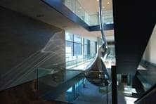 Eine futuristisch anmutende Skulptur erstreckt sich über mehrere Stockwerke im Innenhof eines Gebäudes.