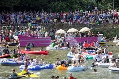 Etliche Menschen in Schlauchbooten treiben auf der Donau.