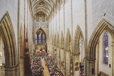 Das Kirchenschiff des Ulmer Münsters mit hunderten von Besuchern, die dem Philharmonischen Orchester zuhören.