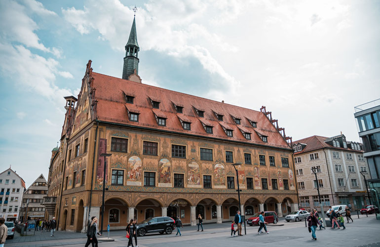 Das Rathaus mit seiner bemalten Nordwand, seinem roten Dach und spitzem Turm.