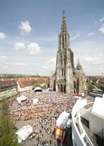 Der Münsterplatz aus der Vogelperspektive. Am rechten Rand ist das Stadthaus, mittig hinten das Münster, auf dem Platz selber äuft eine Veranstaltung mit einer Menschenansammlung.