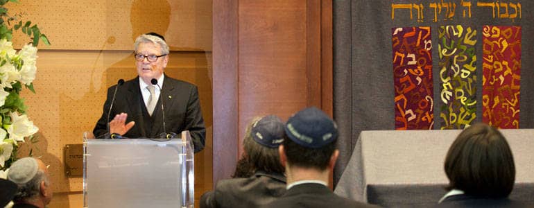 Joachim Gauck steht in der Synagoge am Rednerpult. Er trägt eine Kippa, eine kleine kreisrunde Mütze, die Männer jüdischen Glaubens tragen.