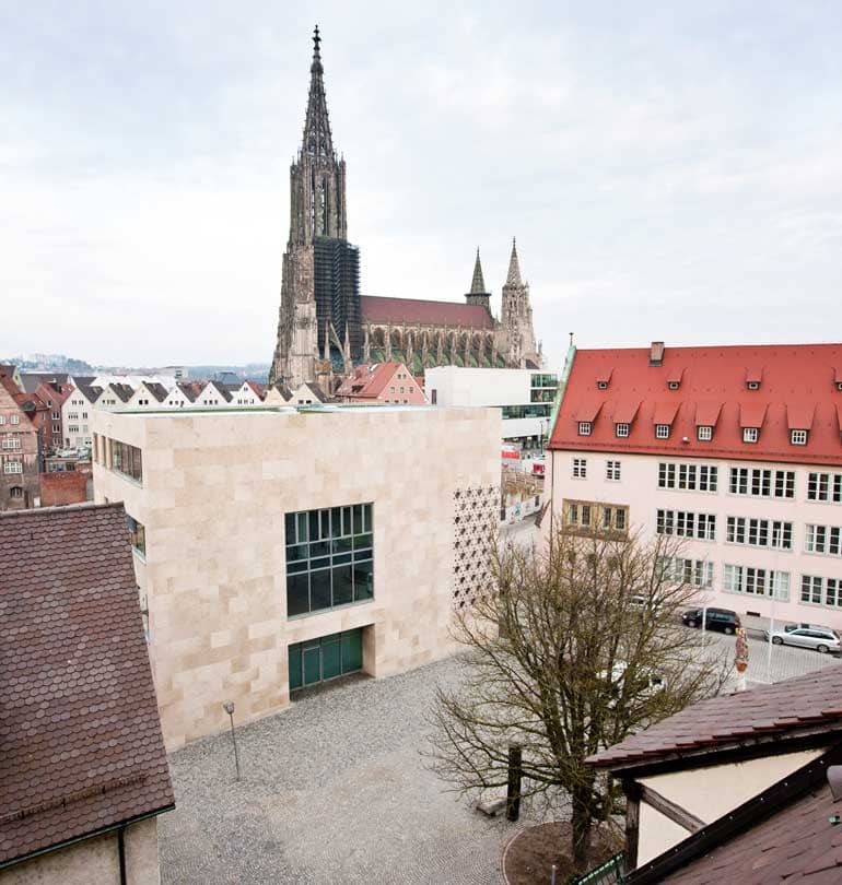 Blick von oben auf den Weinhof, die Synagoge und die umliegenden Dächer. Im Hintergrund erhebt sich das Münster.
