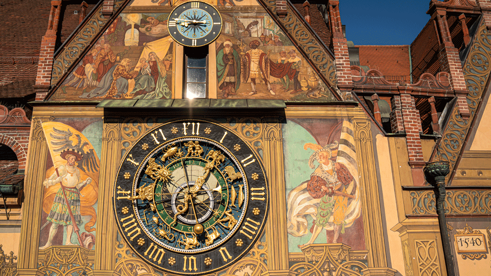 Die astronomische Uhr ist in mehreren Metern Höhe an der Wand des Rathauses angebracht.