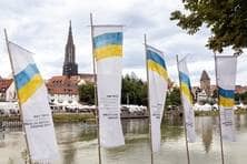 Fahnen mit den Nationalfarben der Ukraine säumen das Donauufer