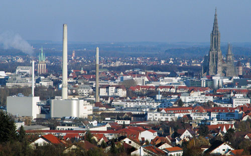 Stadtpanorama mit einer Industrieanalage im Vordergrund
