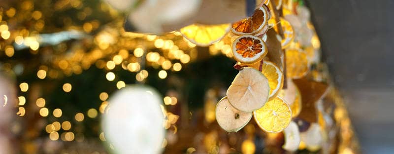 An einem Stand auf dem Ulmer Weihnachtsmarkt hängen getrocknete Orangenscheiben als Dekoration.