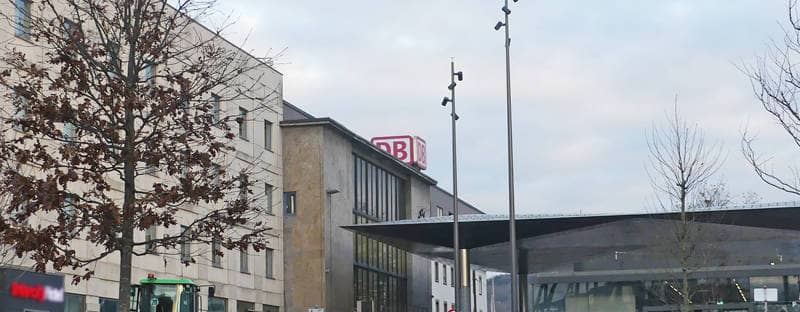 Die Bahnhofshalle ist ein rechteckiges Gebäude, an dem oben das Logo der Deutschen Bahn "DB" angebracht ist.