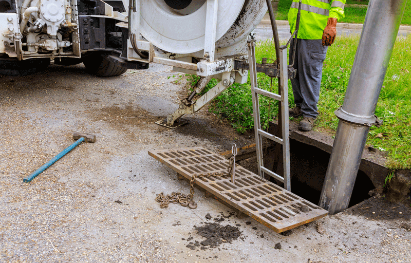Mithilfe eines Industriereinigungswagens für Abwasserreinigung wird eine Verstopfung in einer Abwasserleitung beseitigt.