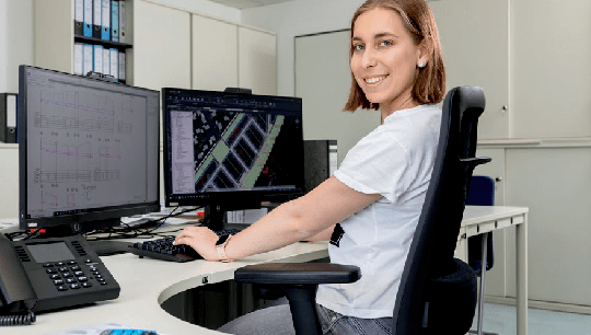 Eine junge Frau am PC Arbeitsplatz